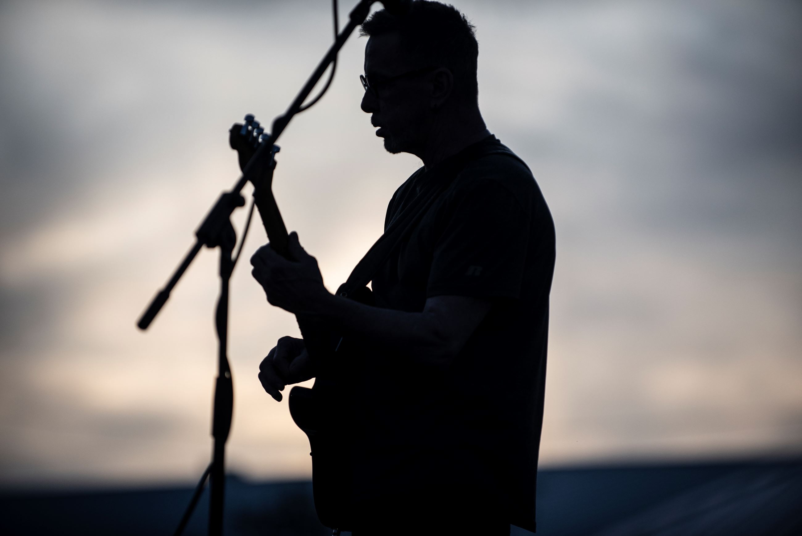 Photo of man playing guitar at sunset
